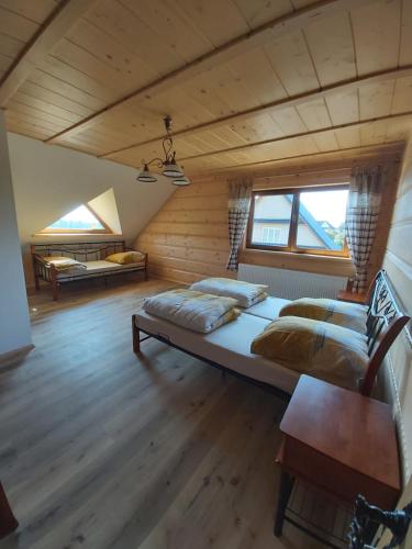 um quarto com 2 camas num quarto com pisos em madeira em Agroturystyka u Guta em Podszkle-Bukowina