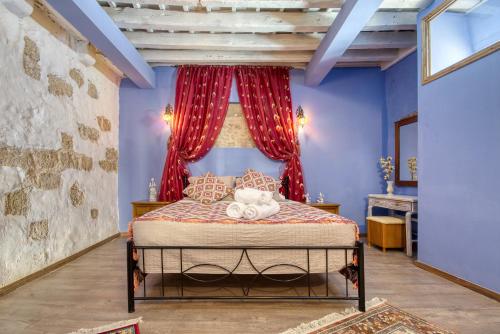 a bedroom with a bed with red curtains at Fatma Hanoum boutique hotel in Rhodes Town