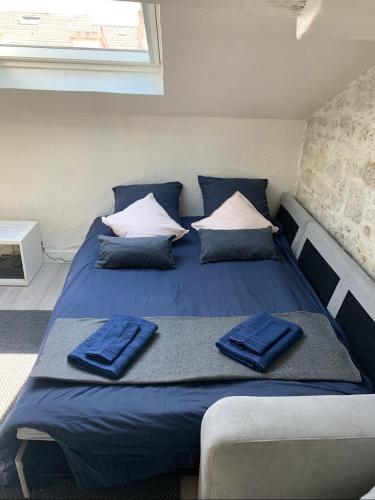 Ce lit se trouve dans un dortoir doté de draps et d'oreillers bleus. dans l'établissement Mansarde Cannes, à Cannes