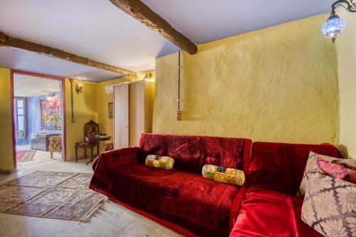 a red couch in a living room with a yellow wall at Fatma Hanoum boutique hotel in Rhodes Town