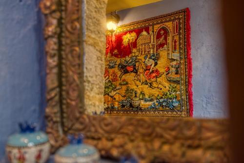 a mirror on a wall with a painting on it at Fatma Hanoum boutique hotel in Rhodes Town