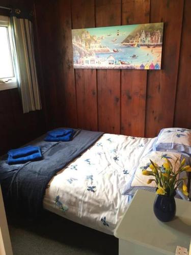 sypialnia z łóżkiem i wazonem kwiatów w obiekcie No 27 A dog friendly rural coastal chalet w mieście Seaton