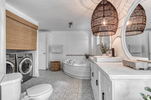 a bathroom with a toilet and a sink and a washing machine at MOWEB - CHALET BORD DE L'EAU AVEC PLAGE iLE ORLEANS in Saint-Laurent-de-l'ile d'Orleans