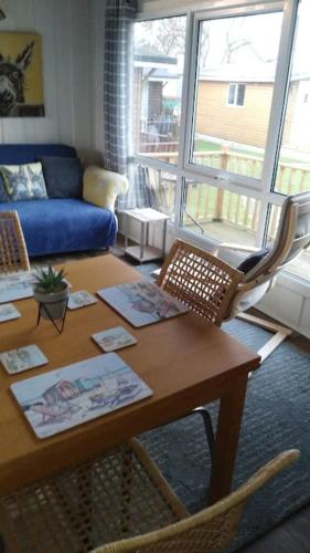 a living room with a table and a couch at No 27 A dog friendly rural coastal chalet in Seaton