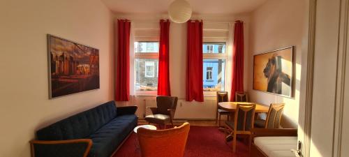 a living room with a couch and a table and windows at 3Zimmer-Wohnküche-Altbau-90m2-eigener Parkplatz in Oberhausen