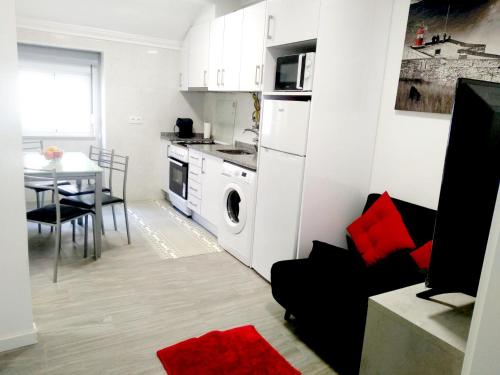 a kitchen and dining room with a table and a white kitchen at Sol e praia in Nazaré