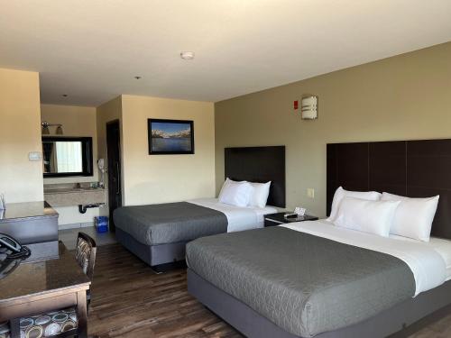 Habitación de hotel con 2 camas y baño en Yosemite Sierra Inn en Oakhurst