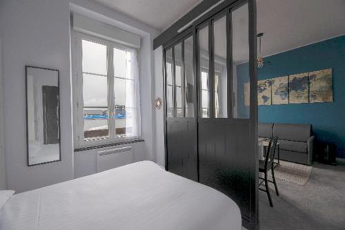 a bedroom with a bed and a room with a couch at Studio cozy proche Intra-Muros in Saint Malo