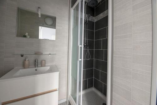 a bathroom with a white sink and a shower at Studio cozy proche Intra-Muros in Saint Malo