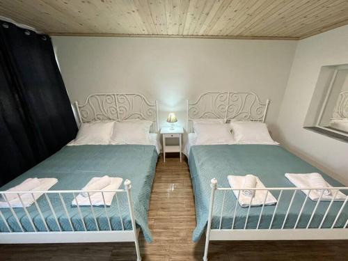 1 dormitorio con 2 camas y mesa con lámpara en Villa Eftychia, en Kissamos