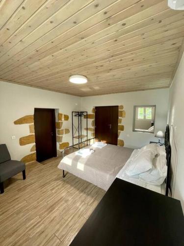 a bedroom with a bed and a wooden ceiling at Villa Eftychia Serene Getaway with Hot Tub in a Quiet Location in Kissamos