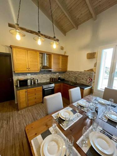 a kitchen with a wooden table with white plates on it at Villa Eftychia Serene Getaway with Hot Tub in a Quiet Location in Kissamos