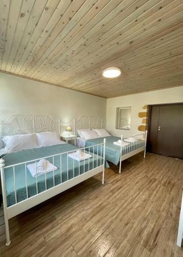 a bedroom with two beds and a wooden ceiling at Villa Eftychia Serene Getaway with Hot Tub in a Quiet Location in Kissamos