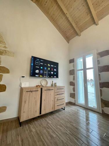 a living room with a tv on the wall at Villa Eftychia Serene Getaway with Hot Tub in a Quiet Location in Kissamos