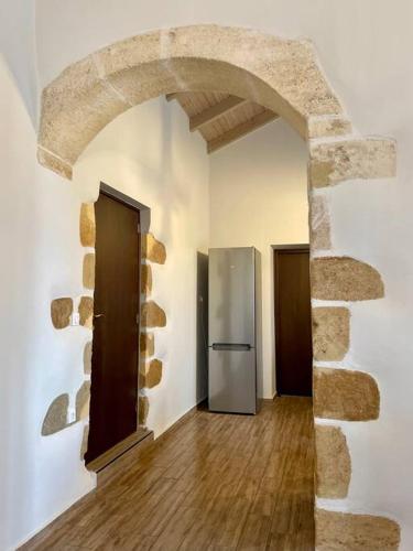 a kitchen with an archway and a refrigerator in a room at Villa Eftychia Serene Getaway with Hot Tub in a Quiet Location in Kissamos
