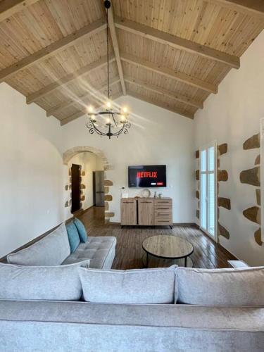 a living room with a couch and a tv at Villa Eftychia Serene Getaway with Hot Tub in a Quiet Location in Kissamos