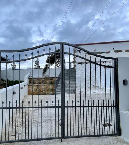a black metal gate in front of a building at Villa Eftychia Serene Getaway with Hot Tub in a Quiet Location in Kissamos