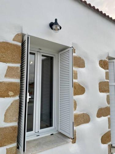 a window on the side of a stone building at Villa Eftychia Serene Getaway with Hot Tub in a Quiet Location in Kissamos