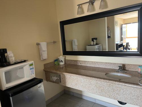 a bathroom with a sink and a microwave at Yosemite Sierra Inn in Oakhurst
