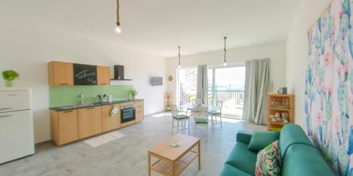sala de estar con sofá verde y cocina en Fior di Sicilia Loft en Marzamemi