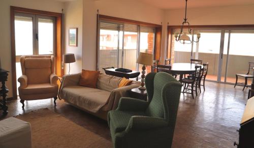 a living room with a couch and chairs and a table at Coimbra Heights in Coimbra