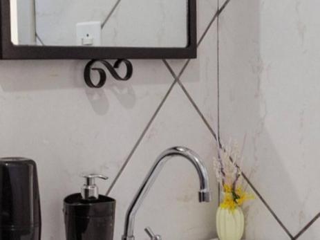 a bathroom sink with a mirror and a faucet at meu cantinho in Tubarão