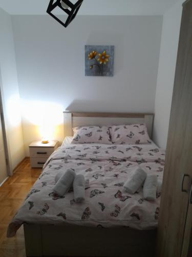 une chambre avec un lit avec un couvre-lit avec des papillons dessus dans l'établissement Holiday apartments, à Niš