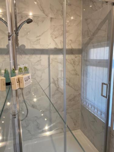 a shower with a glass door in a bathroom at Rodney Parade Mews in Newport