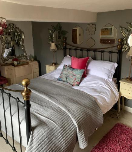 a bedroom with a bed with white and pink pillows at Clarke’s Farm in Heighington