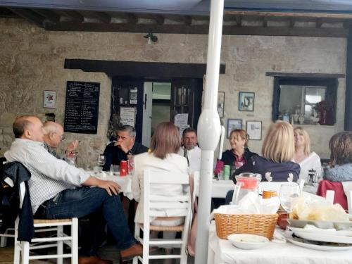 a group of people sitting at tables in a restaurant at Ble Mavi - Studio for 2 in Vouni