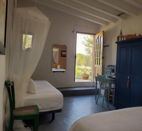 een slaapkamer met 2 bedden en een raam bij Mas de Mingall in Les tres Cales