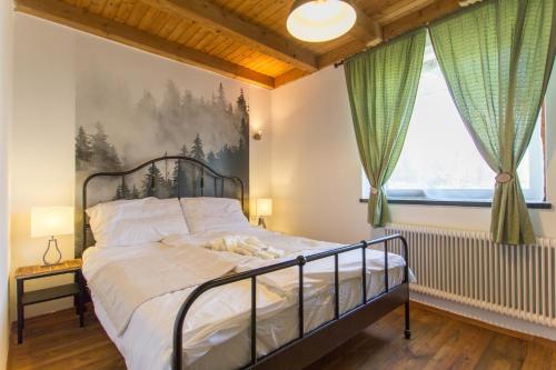 1 dormitorio con 1 cama y una pintura en la pared en Erdőterasz Vendégház - Rusztikus Apartman, en Kehidakustány