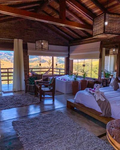 a bedroom with two beds in a room with windows at Pousada Viver a Pedra in Gonçalves