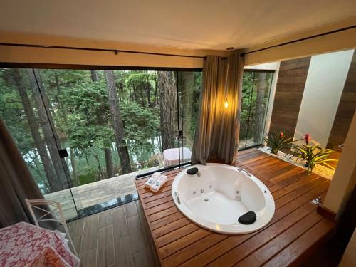y baño con bañera en el suelo de madera. en Pousada Vale das Orquídeas en Lavrinhas