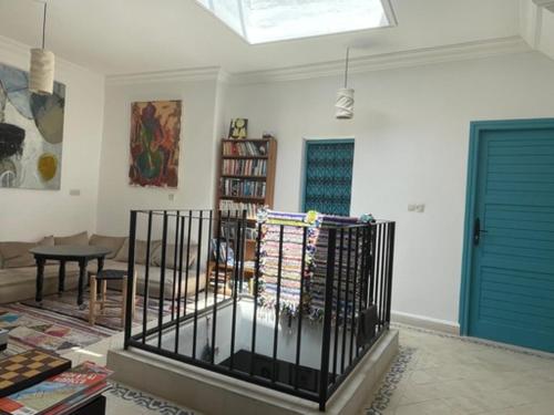 a living room with blue doors and a room with a table at Dar Randigaba in Taroudant