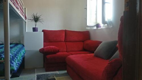 a living room with a red couch and a window at Laredo primera línea de playa,zona puerto deportivo in Laredo