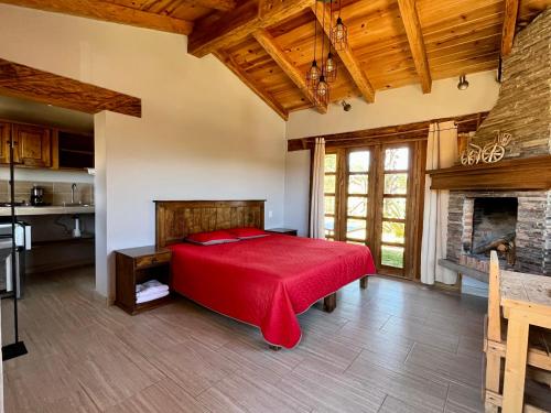 um quarto com uma cama vermelha e uma lareira em Cabaña Puma Tapalpa em Tapalpa