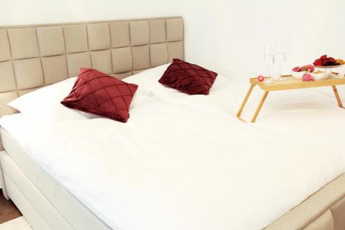 a bed with two pillows and a table on it at SECRET HIDEAWAYS cozySTUDIO 2 superior Apartment mit WiFi nahe Uni l Messe l Flughafen l Zoo in Duisburg
