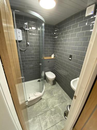 a bathroom with a glass shower and a toilet at Auld Mill House Hotel in Dunfermline