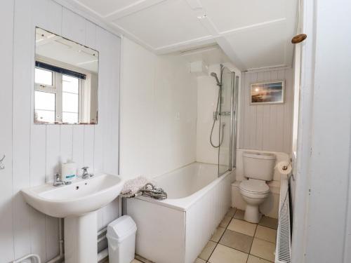 a bathroom with a sink and a tub and a toilet at Ferry Cottage in Sudbourne