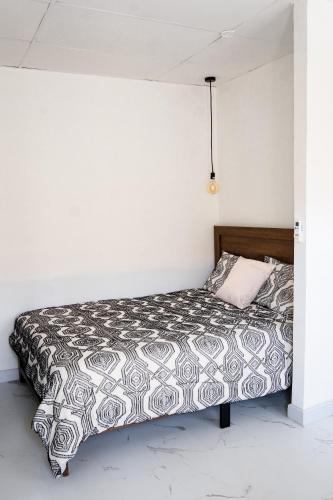 1 dormitorio con 1 cama con colcha en blanco y negro en Doral Executive Apartments, en David