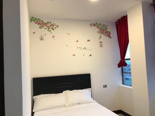 a bedroom with a bed with flowers on the wall at La Fortuna Roja in San José