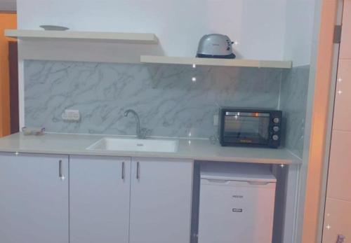 un bancone della cucina con lavello e forno a microonde di Romy suites Deluxe a Netanya