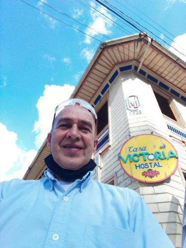 a man is standing in front of a restaurant at HOSTAL CASA VICTORIA PIJAO in Pijao