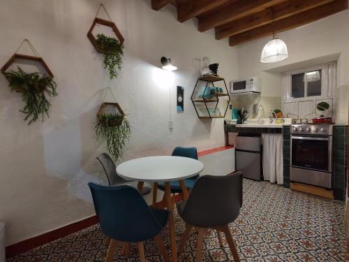 a kitchen with a table and chairs in a room at Terrazas de la Alameda - Panoramic Aparthotel by Lunian in Guanajuato