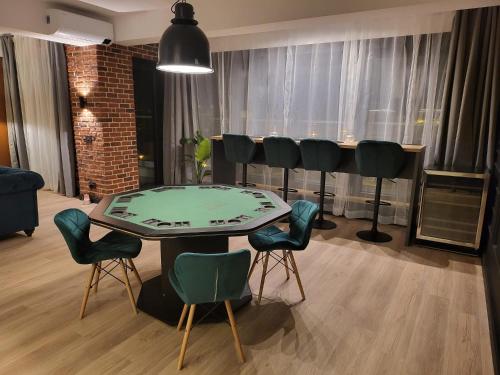 a dining room with a table and green chairs at SPAre-Time - Exclusive and Unique Apartment! 18+ in Oradea
