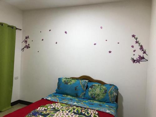 a bedroom with a bed with flowers on the wall at La Fortuna Roja in San José
