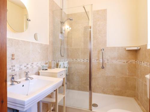 uma casa de banho com um chuveiro e um lavatório. em Barn Owl Cottage em Little Glenham