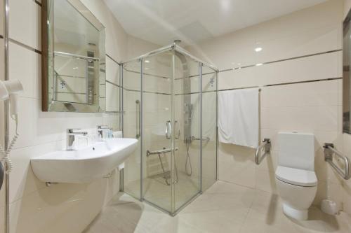 a bathroom with a sink and a shower and a toilet at Gran Hotel Corona Sol in Salamanca