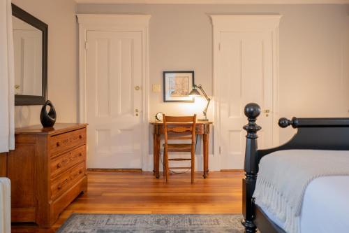 a bedroom with a bed and a desk and a chair at OneSixtyFive, The Inn on Park Row in Brunswick